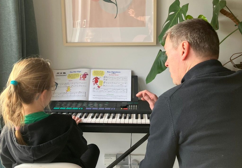 Piano lesson, Robbie is teaching a young girl to play piano